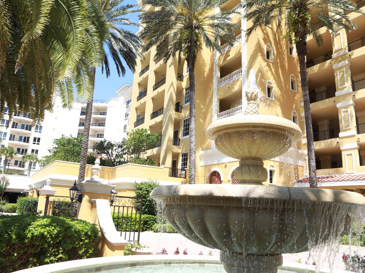 Palm trees and fountain outside a condominium community